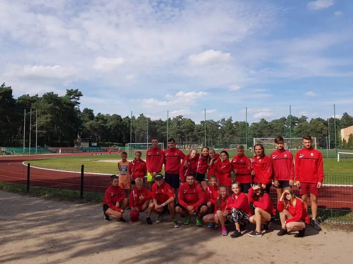 Drużyna sportowa na obozie, zdjęcie grupowe przy bieżni OSiR