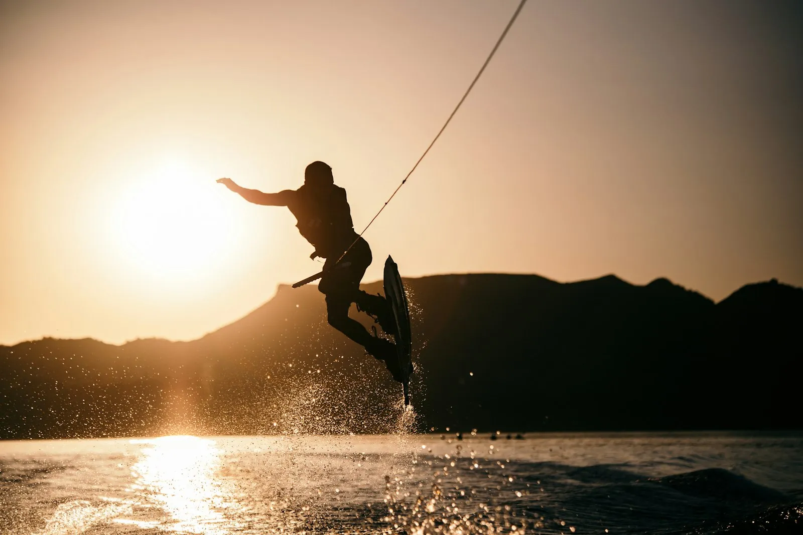 Wakeboarder na linie nad taflą jeziora